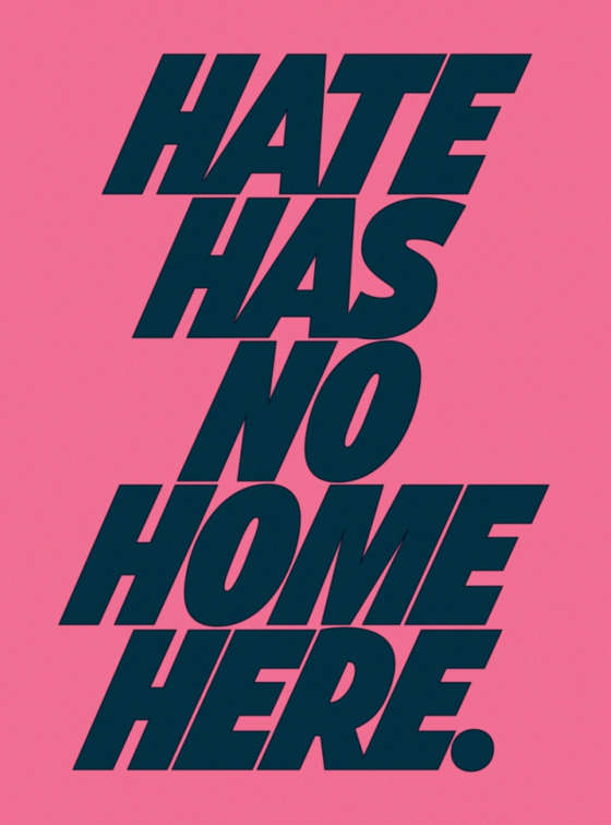 Blue type on pink paper reads "Hate Has No Home Here."